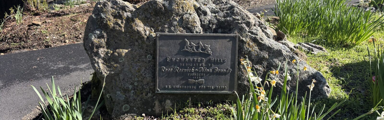 Rock with a plaque that reads, "Enchanted Hills Dedicated to Rose Resnick- Nina Brandt Founders 1950 S.F. Lighthouse for The Blind".