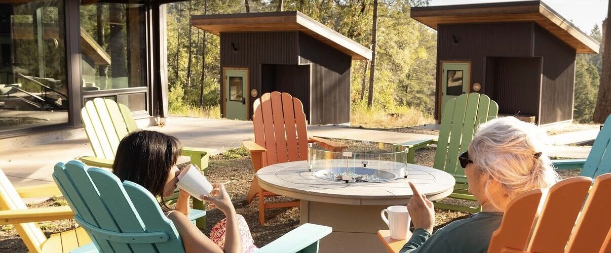 Screenshot 2 women lounging outside at Hillside Village.