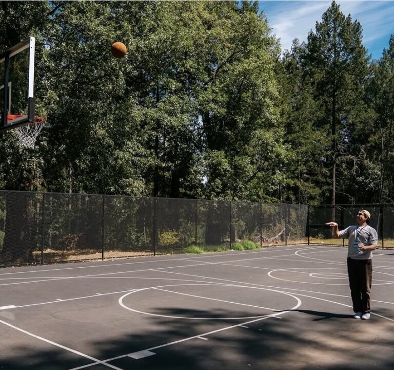 A person shooting a basketball into a basketball hoop.